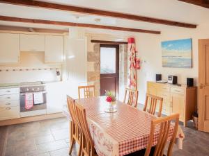 a kitchen and dining room with a table and chairs at Little Content Farm Cottage in Cury