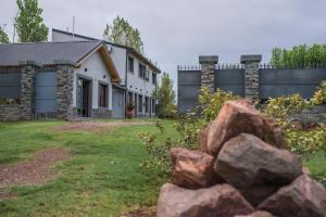 una casa con una valla de piedra y un montón de rocas en Altos la Villa, en San Rafael