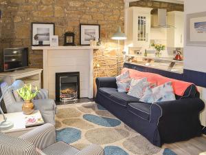 a living room with a couch and a fireplace at Clutter Cottage in Widdrington