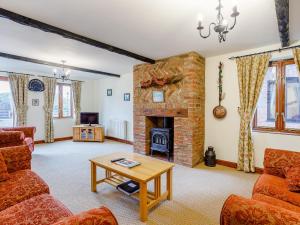 a living room with a brick fireplace and a table at Purlin Barn - E3867 in Runcton Holme