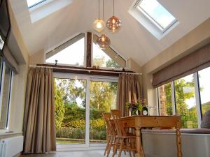 a conservatory with a table and chairs and windows at Garden Cottage in Pooley Bridge