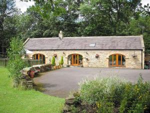 a stone house with a driveway in front of it at Rivers Edge Cottage in Shotley Bridge