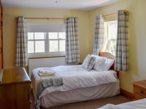 Schlafzimmer mit einem Bett und einem Fenster in der Unterkunft Captains Cottage - E3643 in Whitby