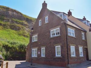 ein großes rotes Backsteingebäude mit weißen Fenstern in der Unterkunft Captains Cottage - E3643 in Whitby