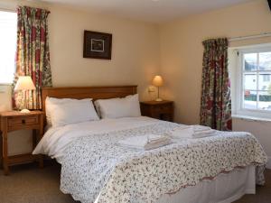 een slaapkamer met een bed met 2 lampen en een raam bij Royal Oak Farm in Winsford