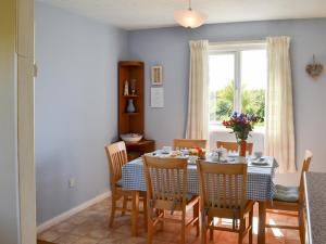 a dining room with a table and chairs and a window at Seafield in Llanrhyddlad