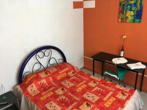 Un dormitorio con una cama y una mesa con una cruz en Habitacion privada en Centro Lopez Mateos con Aire Acondicionado Oficina Estacionamiento en León