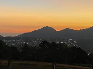 a sunset over a city with mountains in the background at Cabañas Huerta la Mision, Zacatlán in Zacatlán