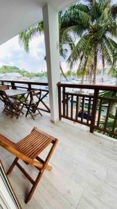 a balcony with a table and chairs and a view of the ocean at Aux vents des rhums au cœur de la Marina du Gosier avec vue imprenable in Pointe-à-Pitre