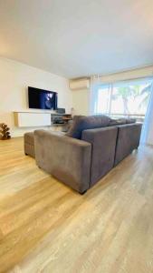 a living room with a couch and a television at Aux vents des rhums au cœur de la Marina du Gosier avec vue imprenable in Pointe-à-Pitre