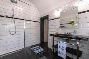 uma casa de banho com um chuveiro, um lavatório e um espelho. em The Old Police House em Fishguard