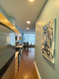 a kitchen with a painting on the wall at Downtown 1BR Condo at Granville Strip near English Bay in Vancouver