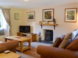 a living room with a couch and a fireplace at Ivy Cottage - Tq4 in Boscastle