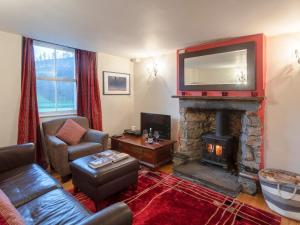 a living room with a fireplace and a television at Catstycam in Thirlmere