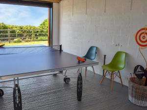 a ping pong table in a room with two chairs at The Bunker in Sennen