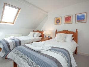 1 Schlafzimmer mit 2 Betten mit weißer Bettwäsche und einem Fenster in der Unterkunft Muffins in Salcombe