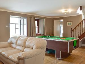 a living room with a pool table and a couch at Brynhowell in Llanglydwen