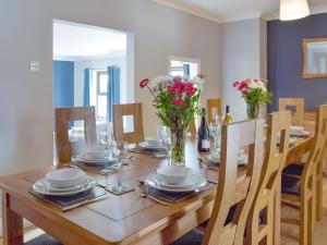 a wooden table with chairs and a dining room at Brynhowell in Llanglydwen