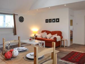 a living room with a couch and a table at Lambs Cottage in Culmstock