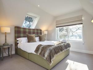 a bedroom with a large bed with a blanket on it at The Indie House in Crieff