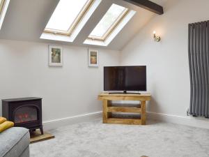 sala de estar con TV de pantalla plana y chimenea en Woodhouse View, en Helsby