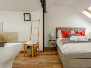 a bedroom with a bed and a bathroom with a bathtub at Wrens Perch in Brixham