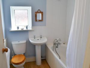 a bathroom with a toilet and a sink and a tub at Jicklings in Wells next the Sea