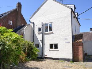 a white house with a window on the side of it at Jicklings in Wells next the Sea