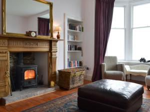 a living room with a fireplace and a mirror at Fircliff - The House On Bute in Port Bannatyne