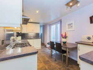 a kitchen with a counter and a table with chairs at Eventide in Pembroke Dock