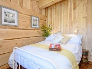 a bedroom with a bed with a wooden wall at Kingfisher Cabin in Croft