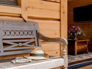 a straw hat sitting on a wooden bench at Kingfisher Cabin in Croft