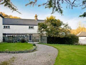 an old stone house with a gravel driveway at Lower Chinkwell-uk12426 in Widecombe in the Moor