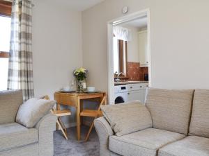 a living room with a couch and a table at Sea Breeze Cottage in Buckie