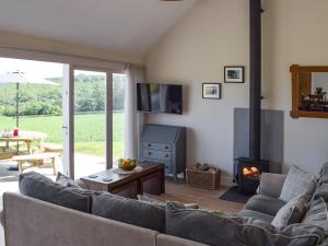 a living room with a couch and a fireplace at Bwthyn Y Bugail in Abercych