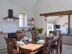 a kitchen and dining room with a wooden table and chairs at Bwthyn Y Bugail in Abercych