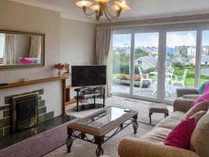 uma sala de estar com lareira e televisão em Swn-y-wylan em Criccieth