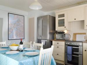 a kitchen with a table with a blue table cloth at Shore Cottage in Arnisdale