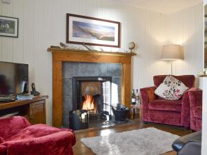 a living room with a fire in a fireplace at Shore Cottage in Arnisdale