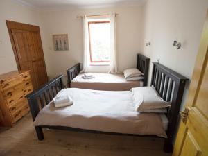 three beds in a room with a window at Uk13326 Pines in Rosemarkie