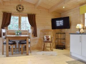 a dining room with a table and a tv on a wall at Brook Cottage - Uk12643 in Sleights