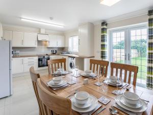 a kitchen and dining room with a wooden table and chairs at Dawson Park 10 - Uk12669 in Mablethorpe