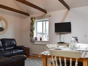 a living room with a table and a tv at Willow in Harrietsham