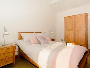 a bedroom with a bed and a wooden cabinet at Bluebell Barn - Uk12792 in Royal Wootton Bassett