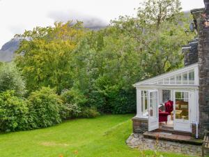 a house with a conservatory on the side of a yard at Trevene in Buttermere