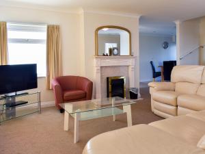 a living room with a couch and a fireplace at Bay View in Carlyon Bay