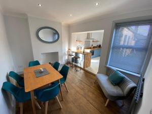 a dining room with a table and chairs and a kitchen at Florence Cottage in Heacham