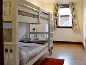 1 dormitorio con 2 literas y ventana en East Lodge, en Kingholm Quay