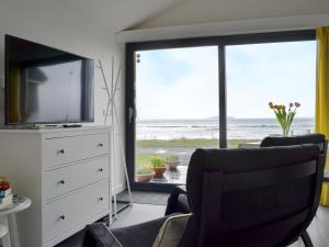 a living room with a tv and a large window at The Isle View Nest - Uk13547 in Broadford