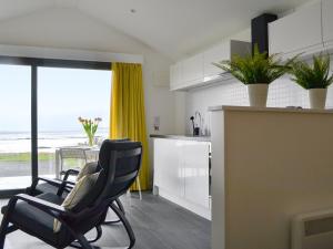 a kitchen with two chairs and a table with a view of the ocean at The Isle View Nest - Uk13547 in Broadford